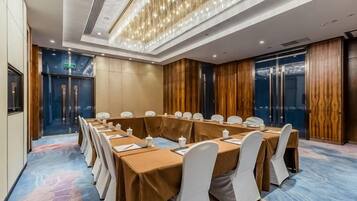 A conference room with a long table, chairs, and a chandelier.