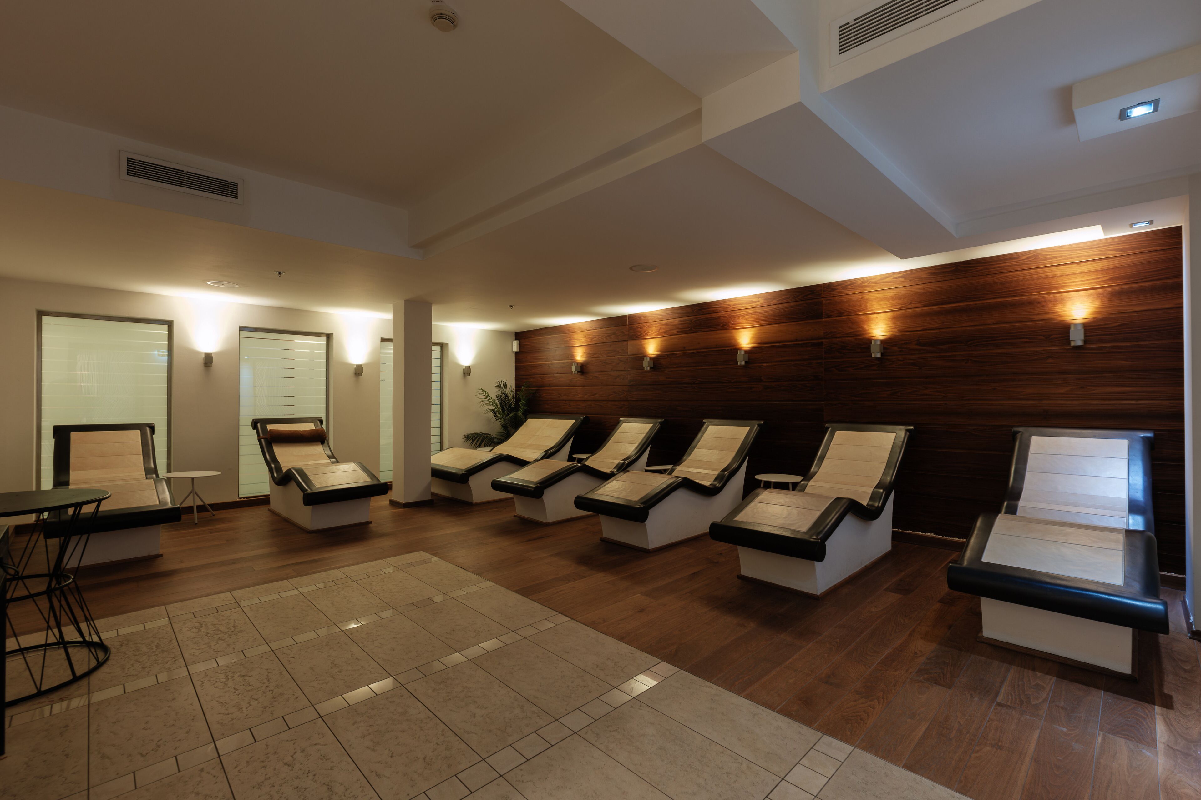 A spa room with multiple massage chairs, a reception desk, and a small table.