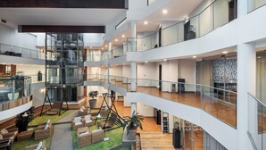 A multi-level atrium with open spaces, seating areas, and a central staircase. - Eurostars Queen of Montenegro (Becici)