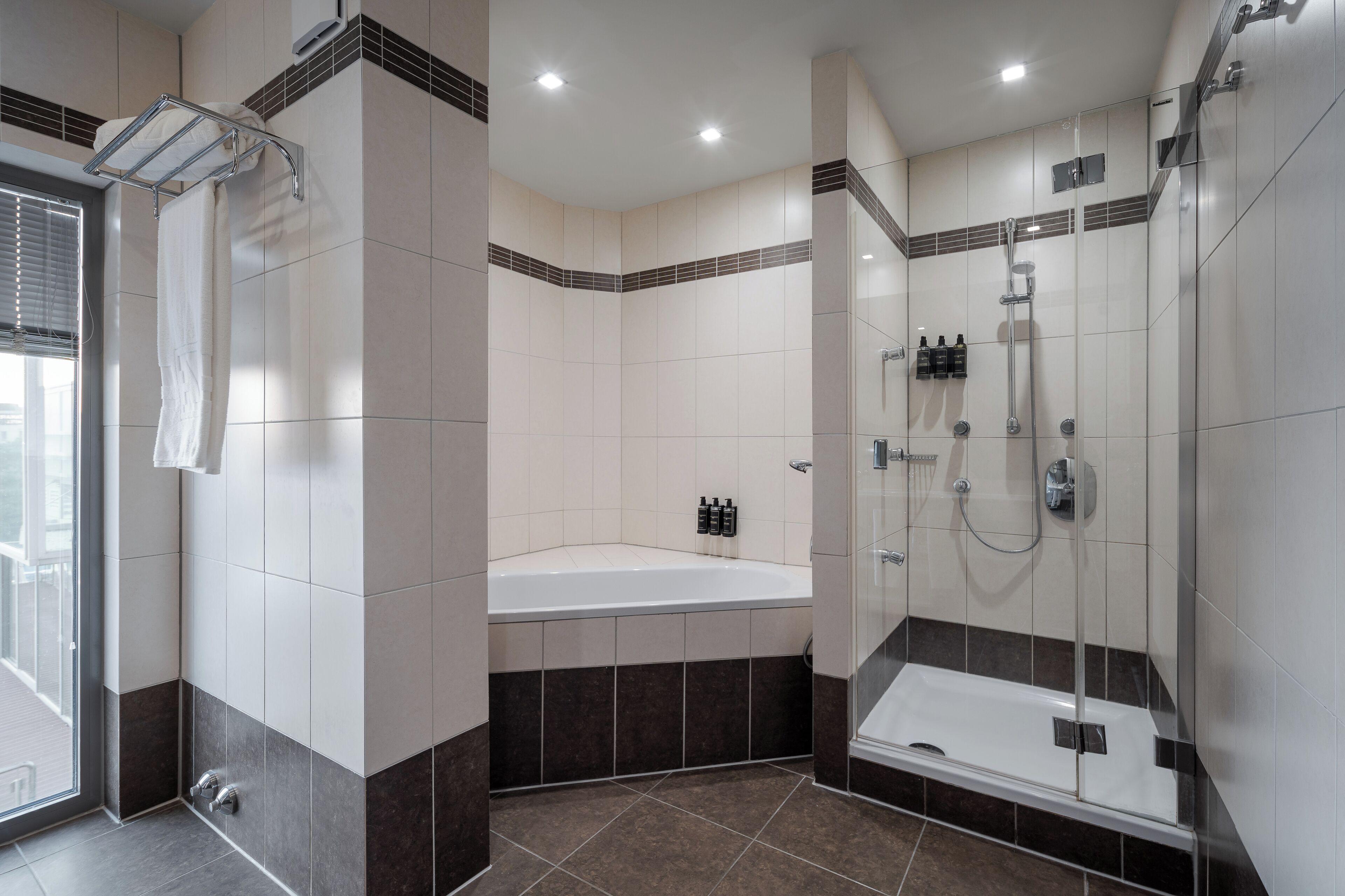 A modern bathroom with a bathtub, shower, and glass-enclosed shower stall.