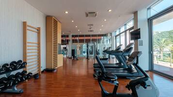 A gym with treadmills, dumbbells, and exercise equipment.