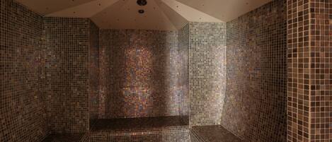 A room with mosaic tiled walls and a bench.
