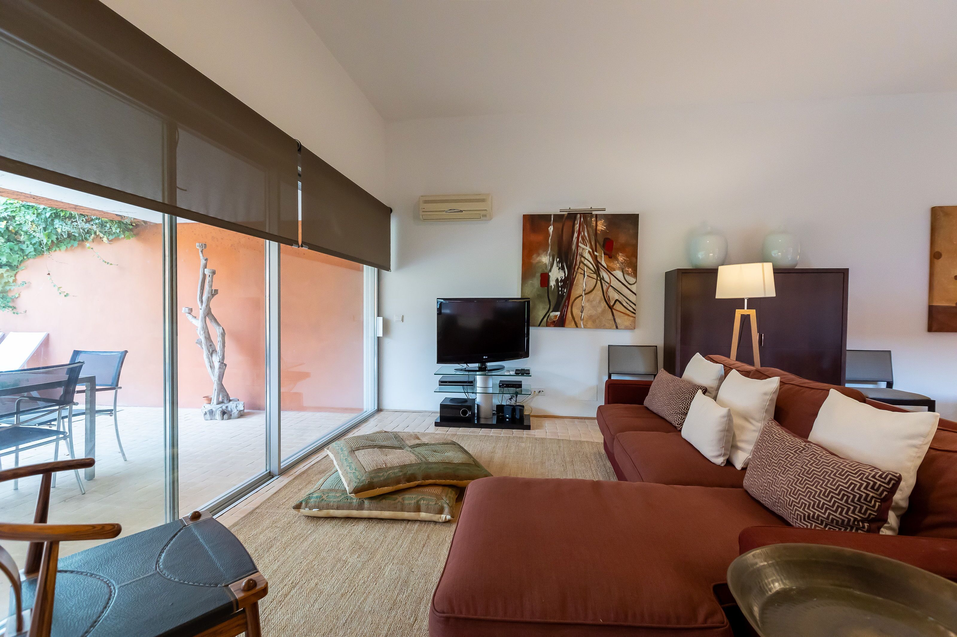 A modern living room with a sofa, TV, and artwork on the wall.