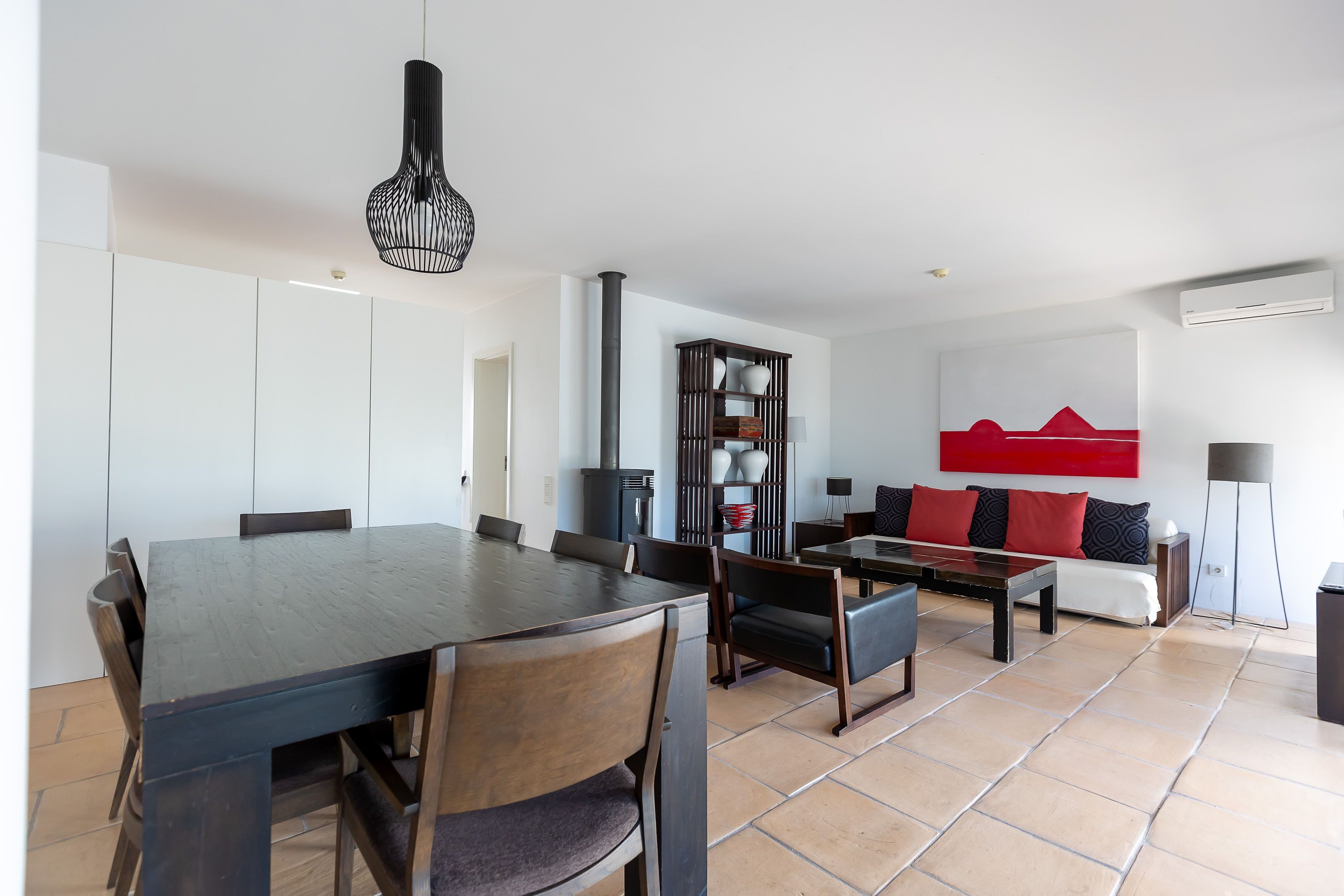 A modern living room with a dining area, featuring a sofa set, a coffee table, and a dining table with chairs.