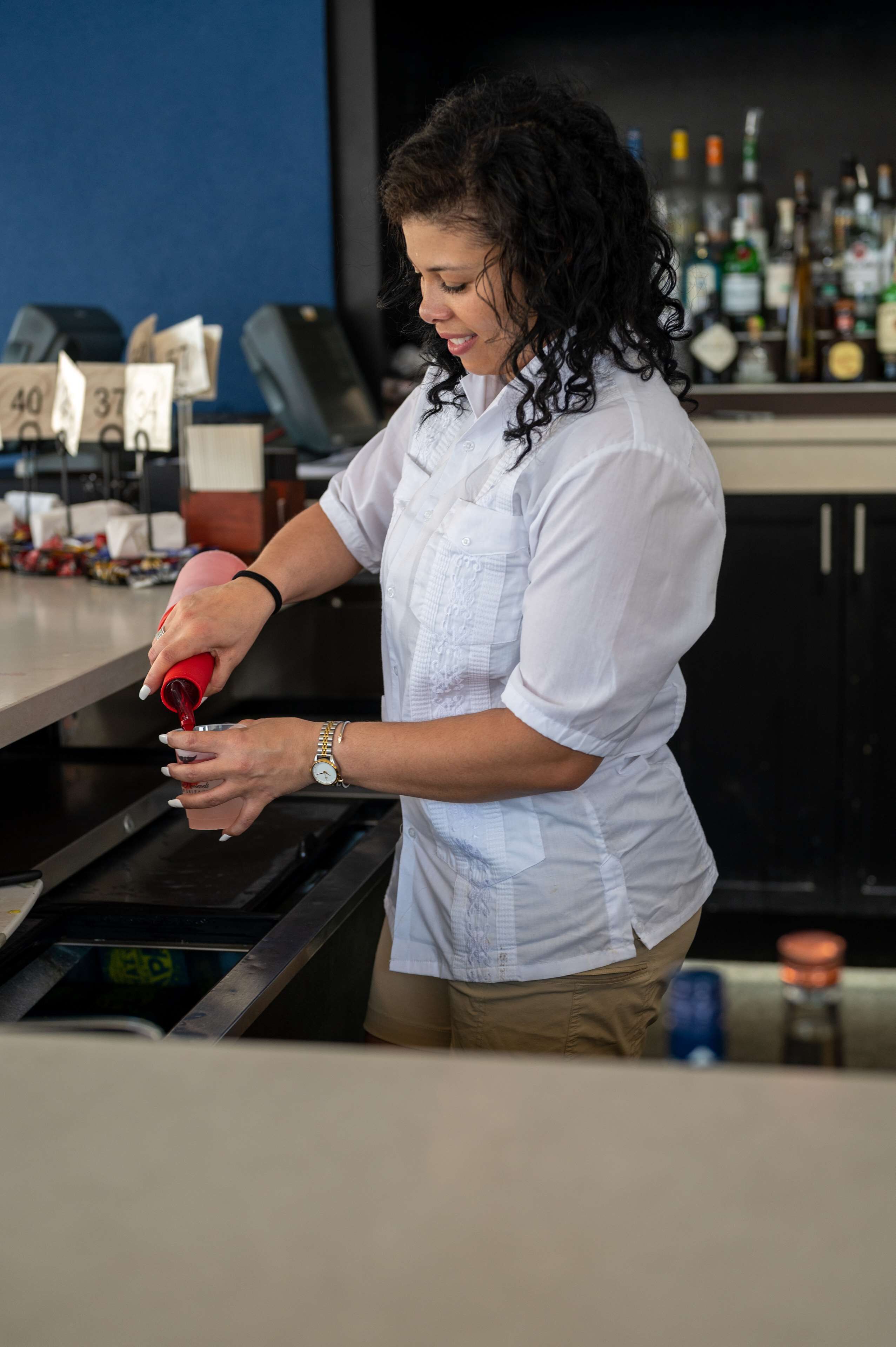 A person pouring a red liquid into a glass.