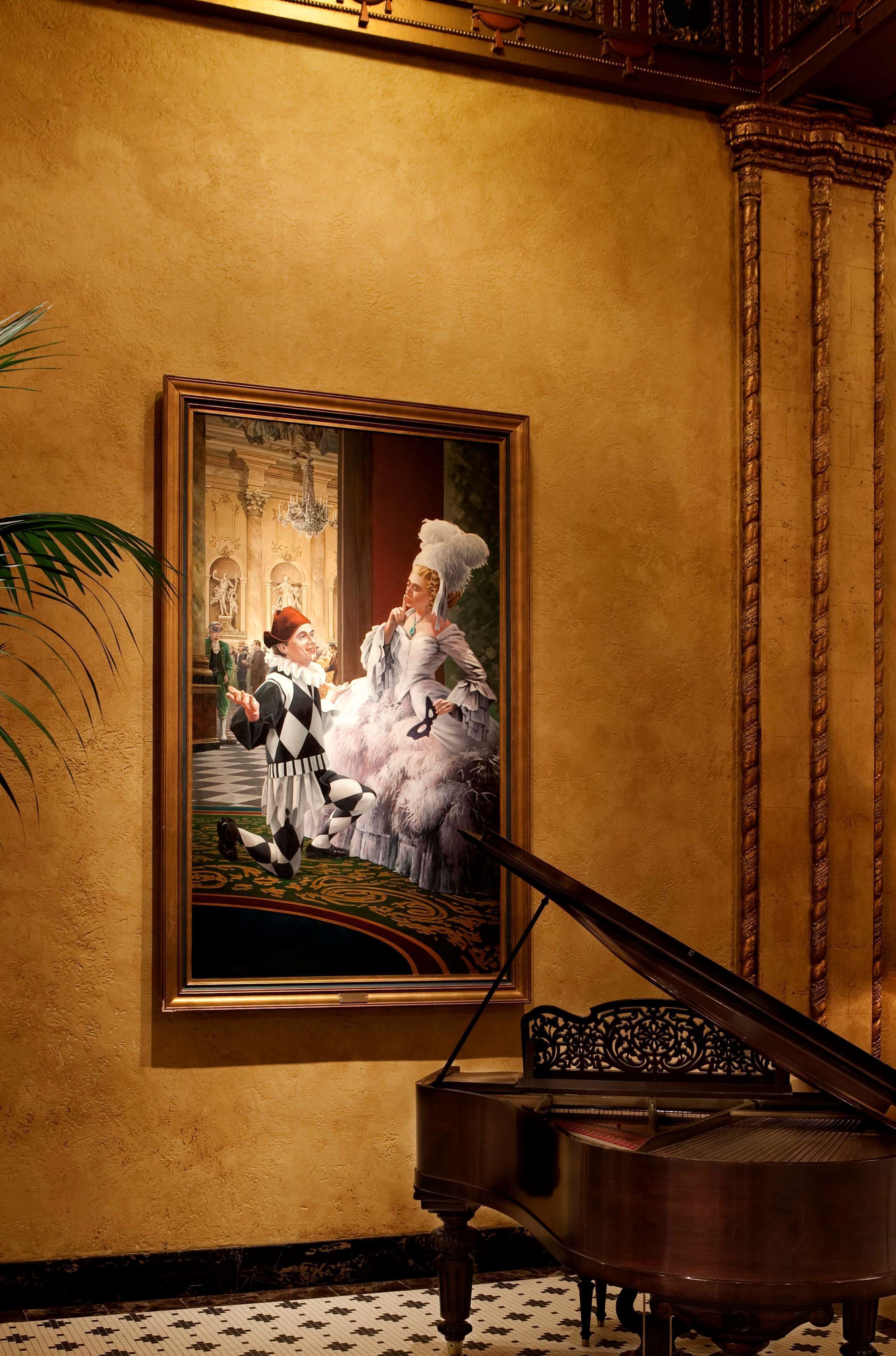 A grand piano in a room with a large framed painting on the wall.