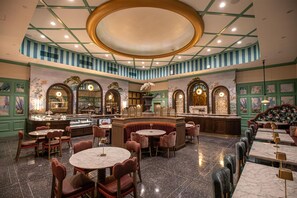 A spacious restaurant with a central bar, multiple seating areas, and a high ceiling with a circular skylight. - The Roosevelt New Orleans, A Waldorf Astoria Hotel (New Orleans)