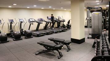 A gym with treadmills, weight machines, and benches.