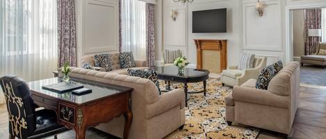 A living room with a sofa set, a coffee table, a TV, and a fireplace.
