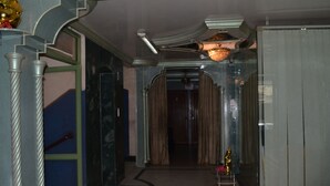 Un passadís amb una escala, un penjallum i una estàtua daurada decorativa.