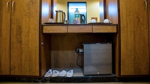 Eine kleine Küchenzeile mit einem Kühlschrank, einer Kaffeemaschine und einer Flasche Bisquick.