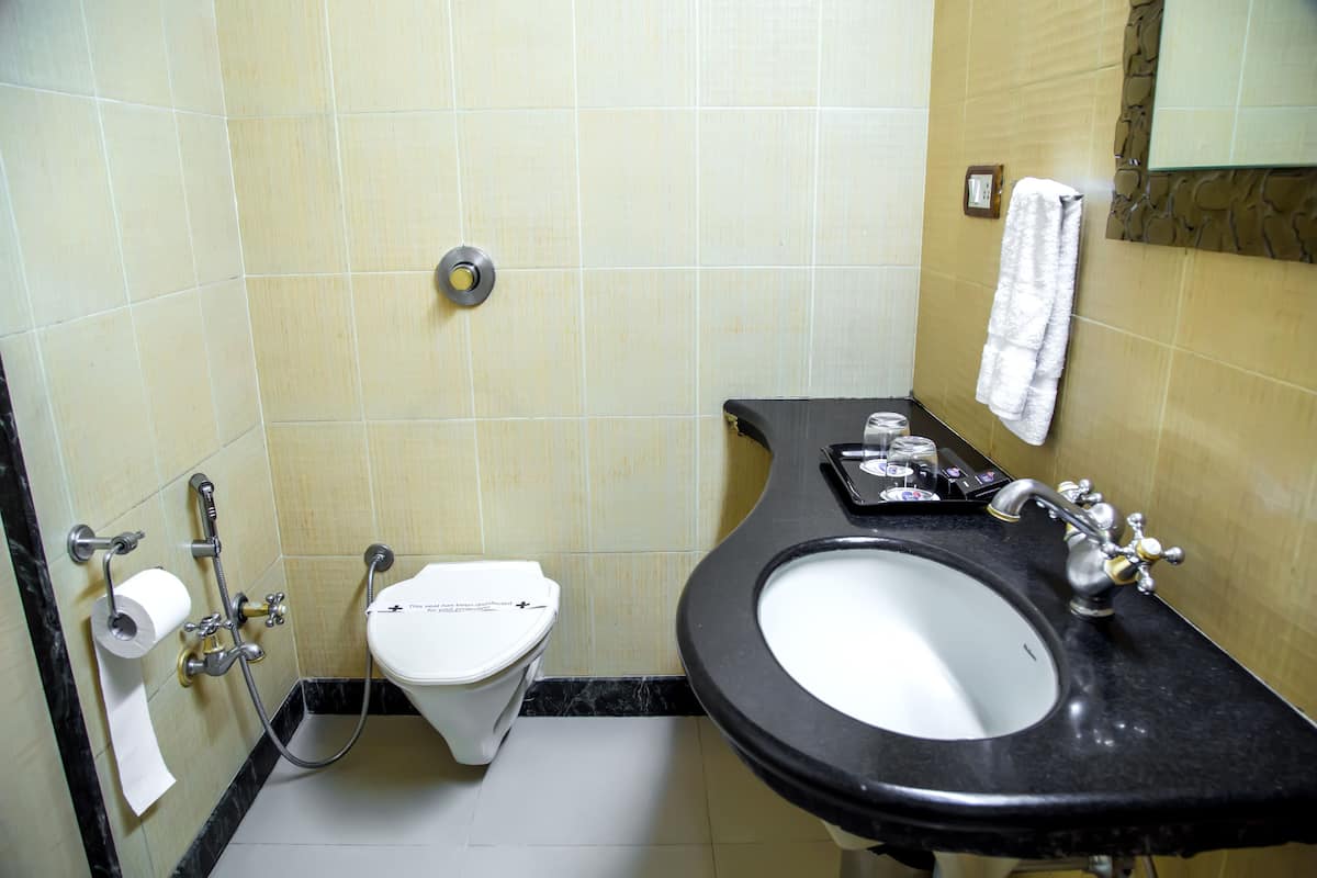 A bathroom with a toilet, sink, and towel rack.