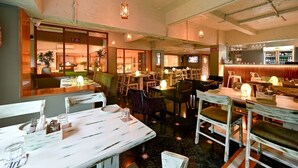 A restaurant with multiple tables and chairs, a bar area, and a television screen. - VITS Sharanam, Thane (Thane)