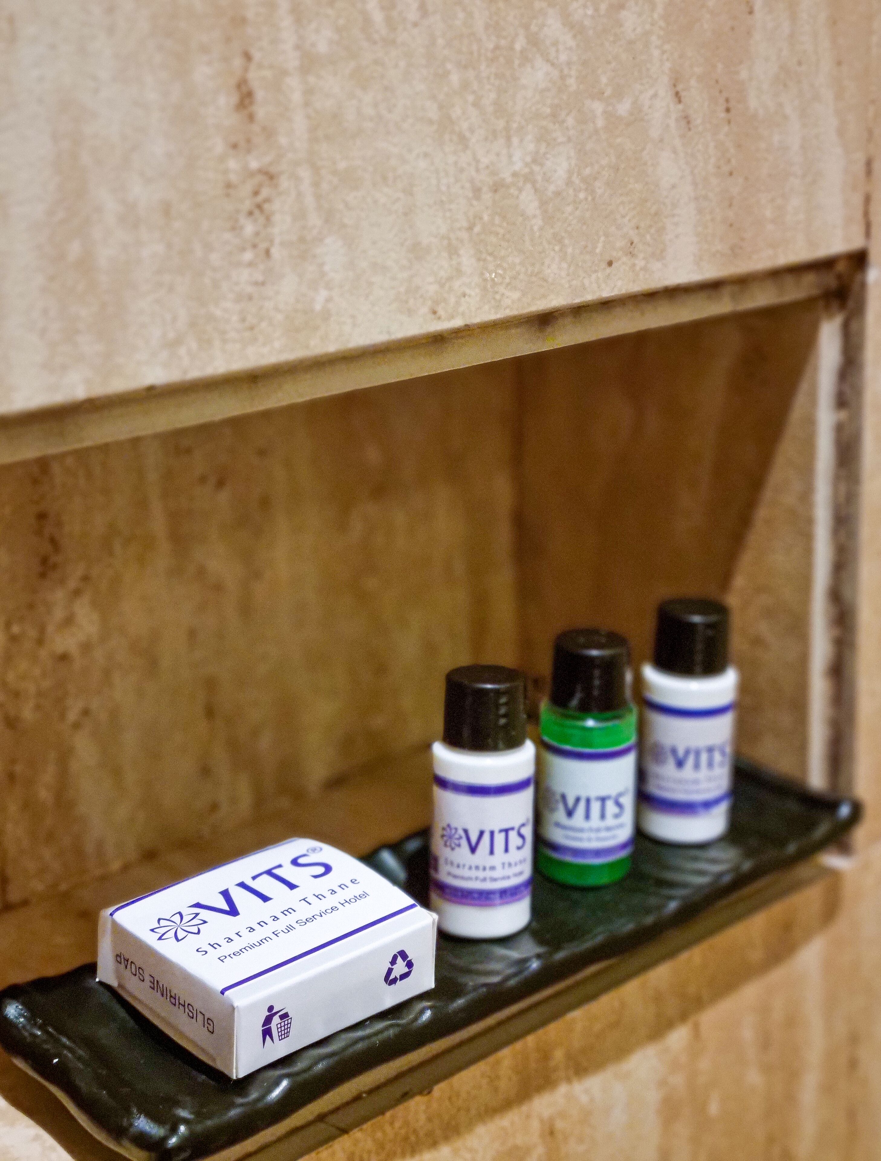 A box of VITS Sharanam Thane Premium Full Service Hotel toiletries on a shelf.