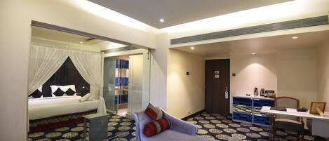 Une chambre d’hôtel avec un lit, un canapé, un bureau et une chaise.