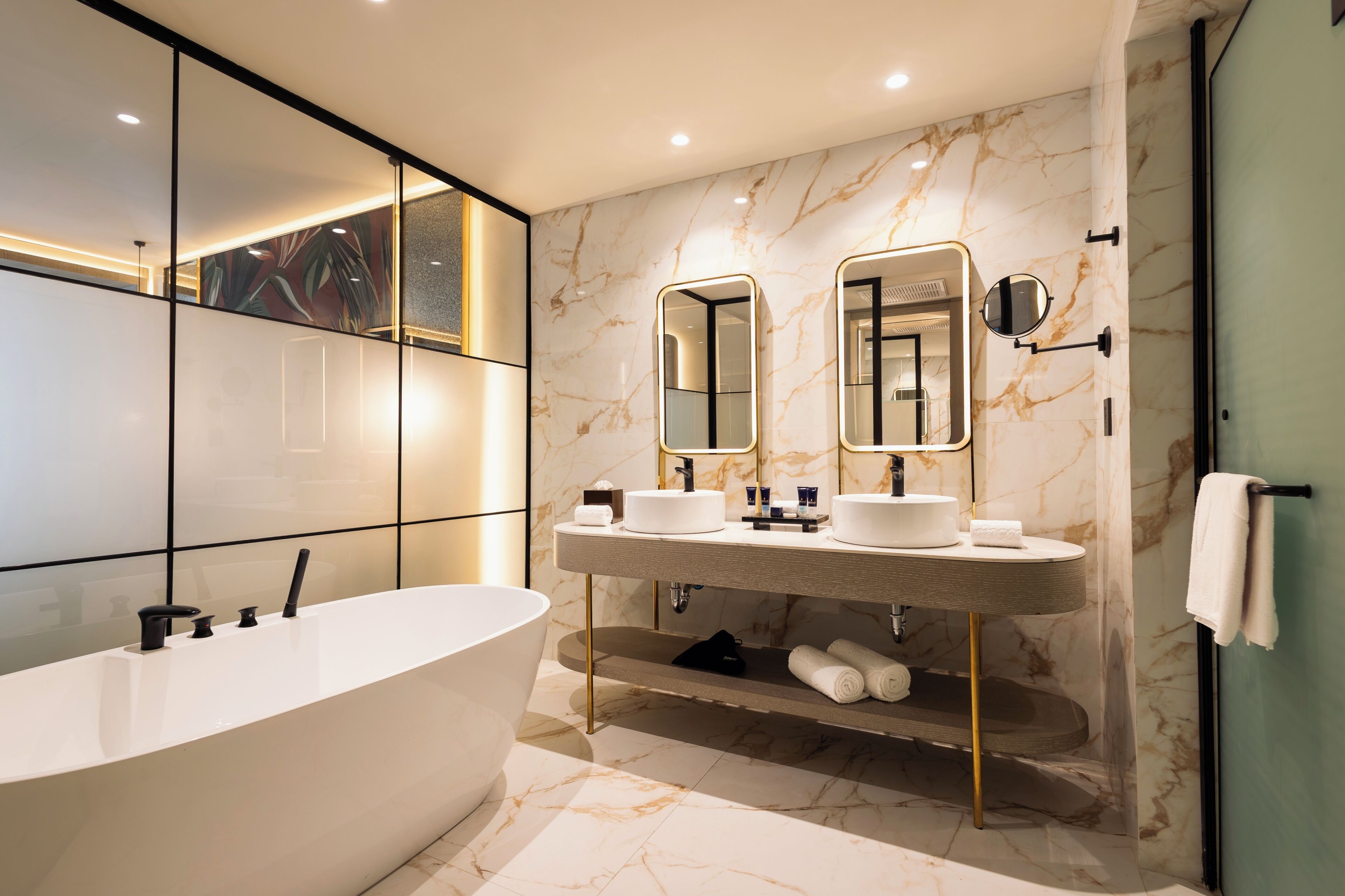 A modern bathroom with a freestanding bathtub, dual sinks, and a large mirror.