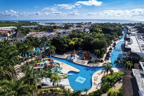 A resort with a large swimming pool, water slides, and a beach area.