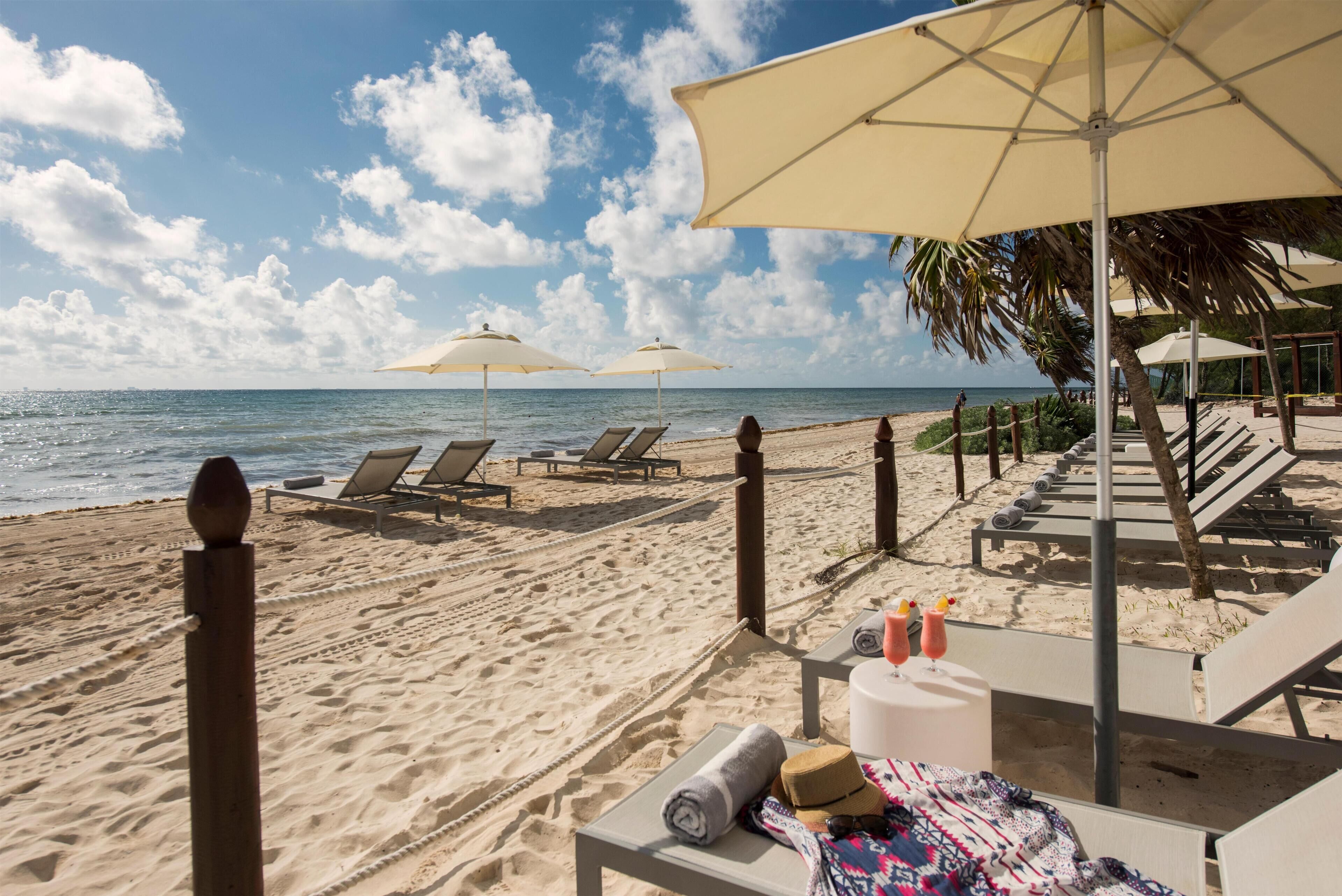 On the beach, white sand, sun loungers, beach umbrellas