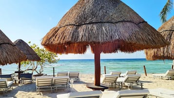 On the beach, white sand, sun loungers, beach umbrellas