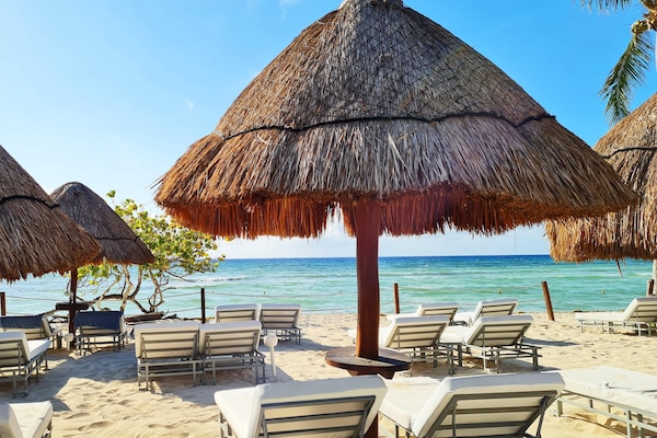 On the beach, white sand, sun-loungers, beach umbrellas