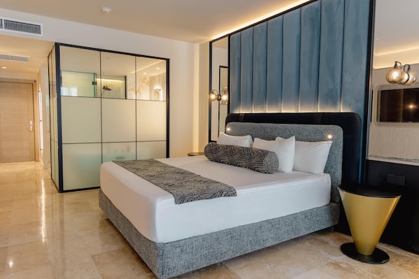 A modern bedroom with a large bed, a built-in wardrobe, and a bedside table. - Grand Riviera Princess - All Inclusive (Playa del Carmen)