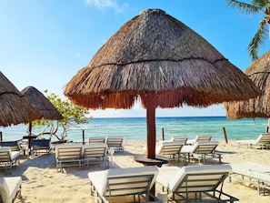 On the beach, white sand, sun loungers, beach umbrellas