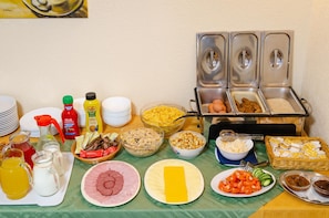Una mesa de buffet con diversos alimentos y salsas.