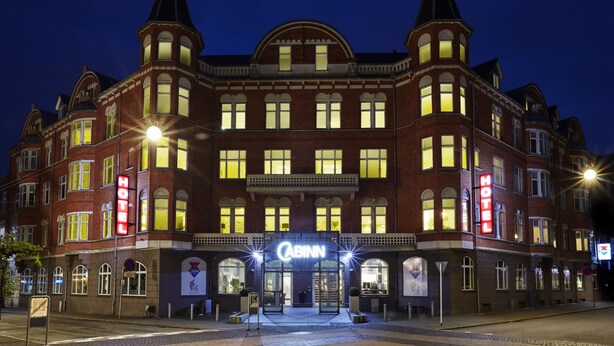 A historic hotel with a prominent entrance, multiple windows, and a distinctive corner turret. - CABINN Esbjerg Hotel (Esbjerg)
