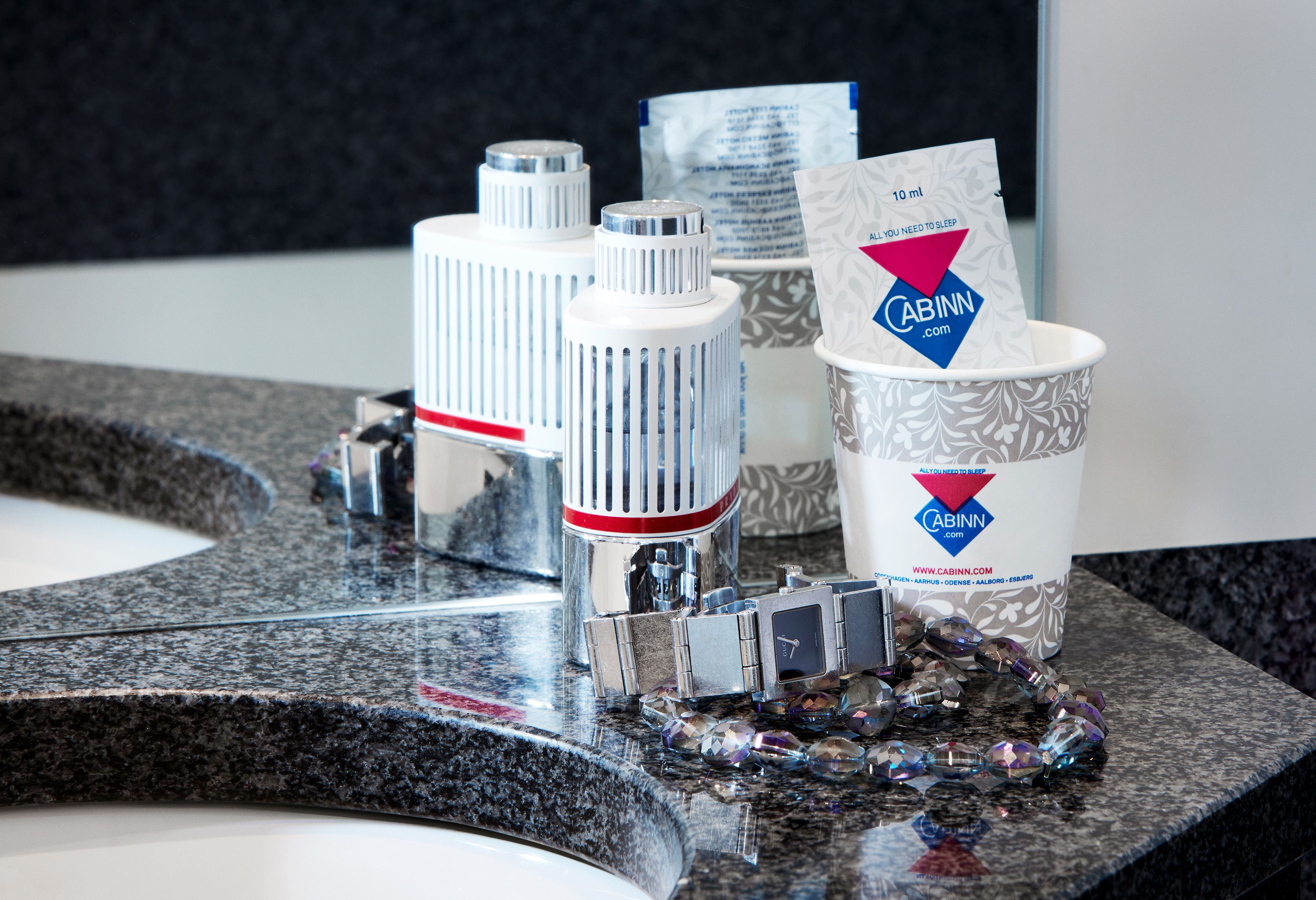 A bathroom vanity with a granite countertop, a mirror, and a sink.