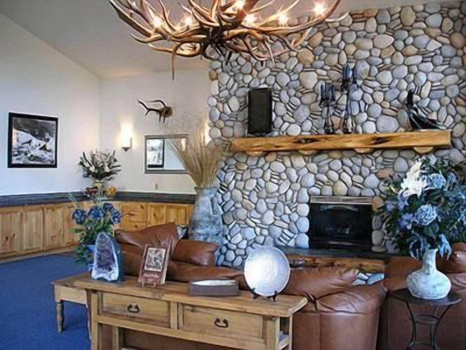 A stone fireplace, leather furniture, and decorative items in a room.