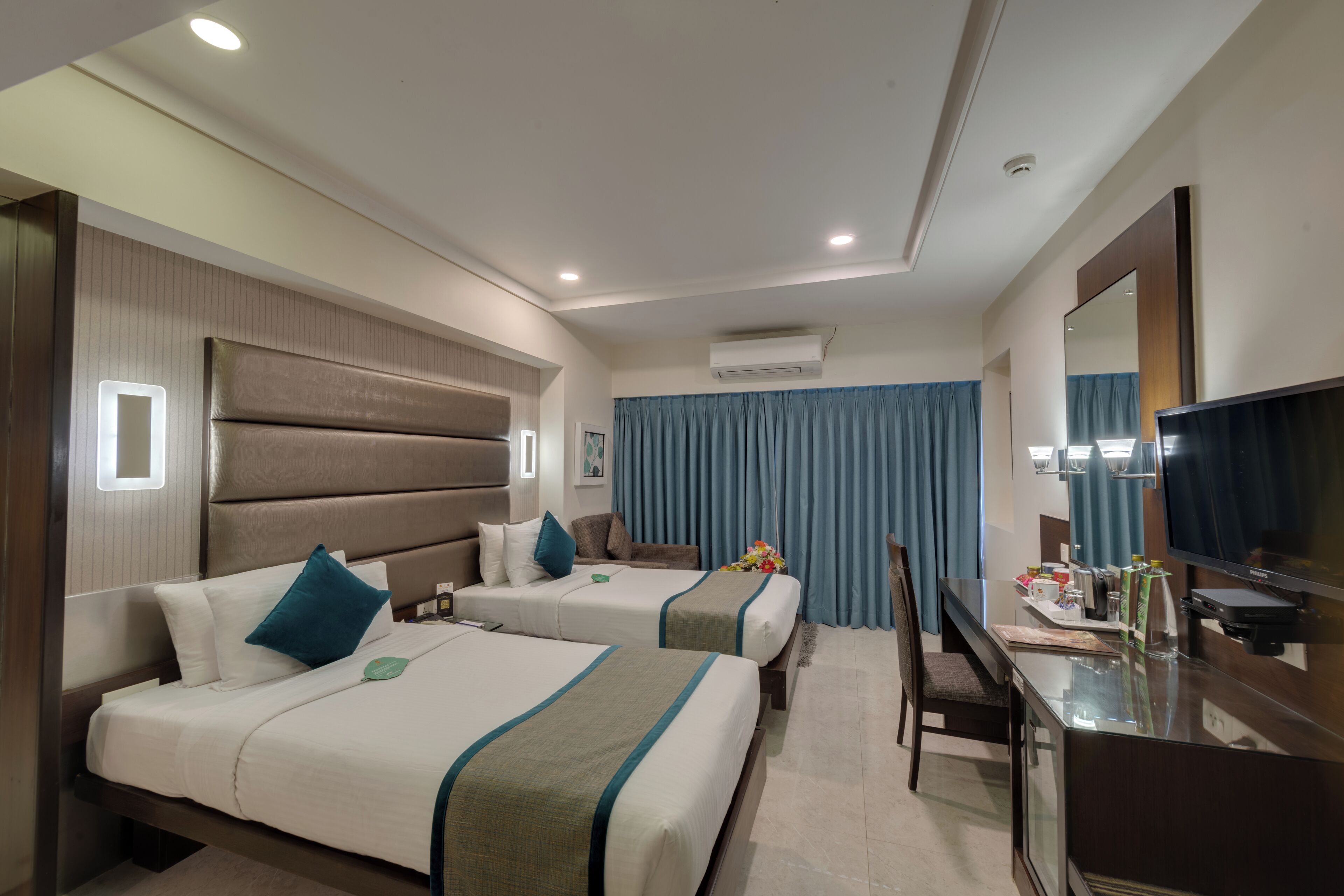 Senger med overmadrass, safe på rommet, skrivebord og blendingsgardiner