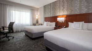 A hotel room with two beds, a desk, a chair, a nightstand, and a patterned wall. - Courtyard Marriott Concord (Concord)
