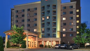 A Courtyard Marriott hotel with a modern design, featuring a prominent entrance with a covered area and multiple parking spaces visible. - Courtyard Marriott Concord (Concord)