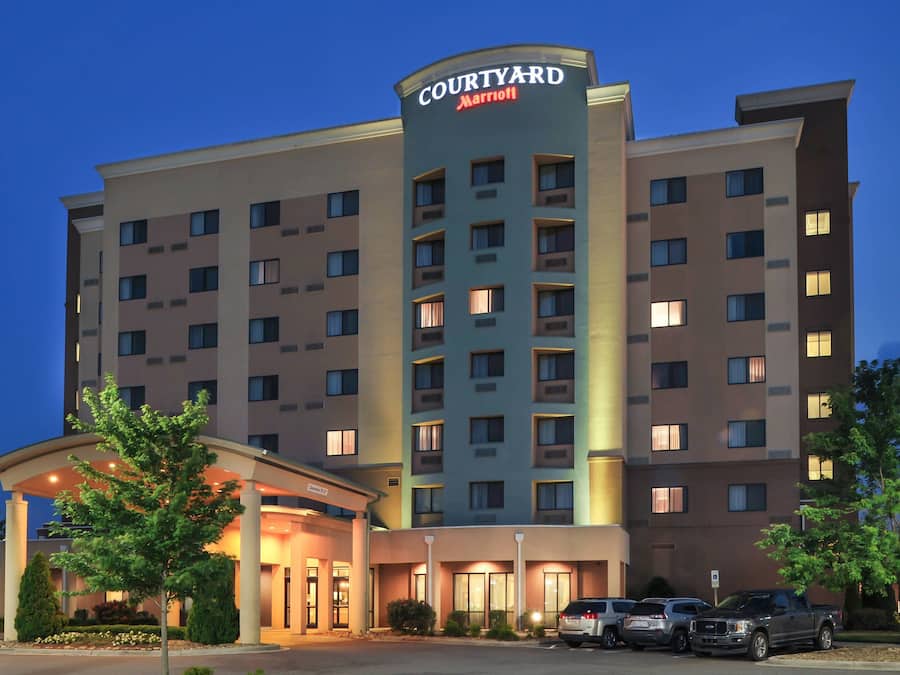 A Courtyard Marriott hotel with a modern design, featuring a prominent entrance with a covered area and multiple parking spaces visible.