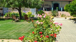 A well-maintained garden with a variety of flowers and a patio area with outdoor furniture. - Quinta do Covanco (Alenquer)
