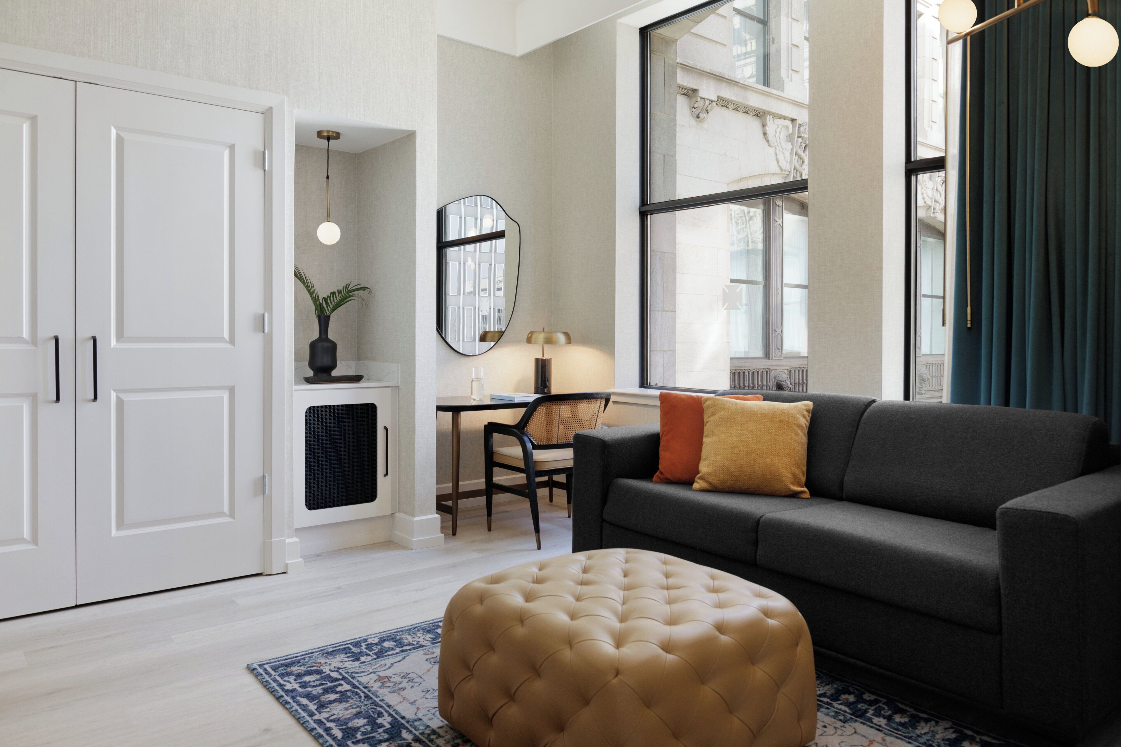 Una sala de estar con sofá, reposapiés y un comedor con una silla y mesa.