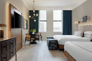 A hotel room with a bed, a desk, a chair, a TV, and a window.