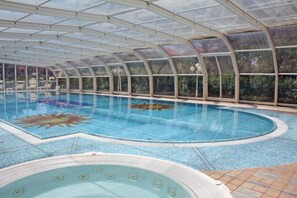 Piscine couverte, piscine extérieure, parasols de plage, chaises longues