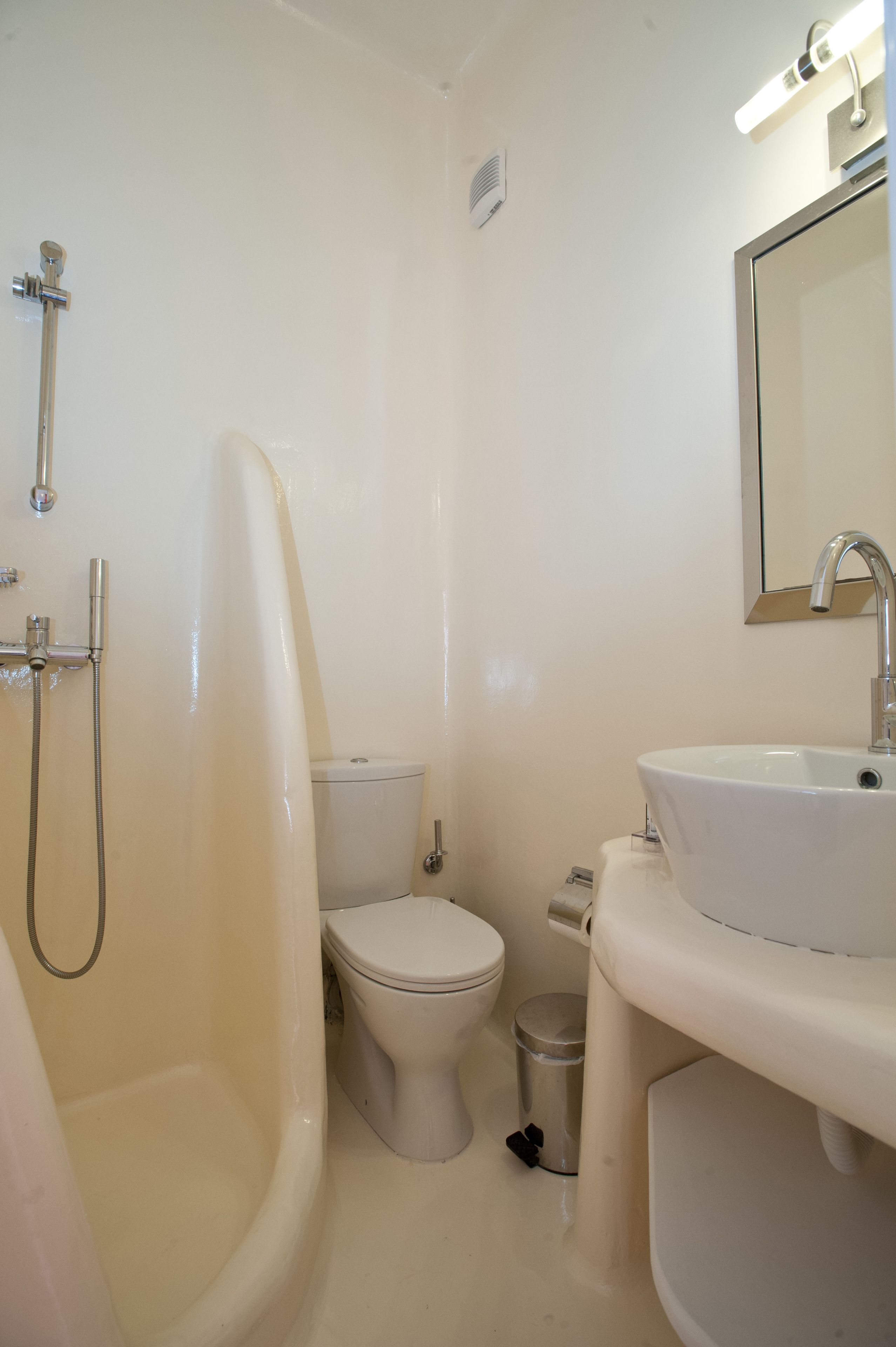 Un baño con bañera, inodoro, lavamanos y espejo.