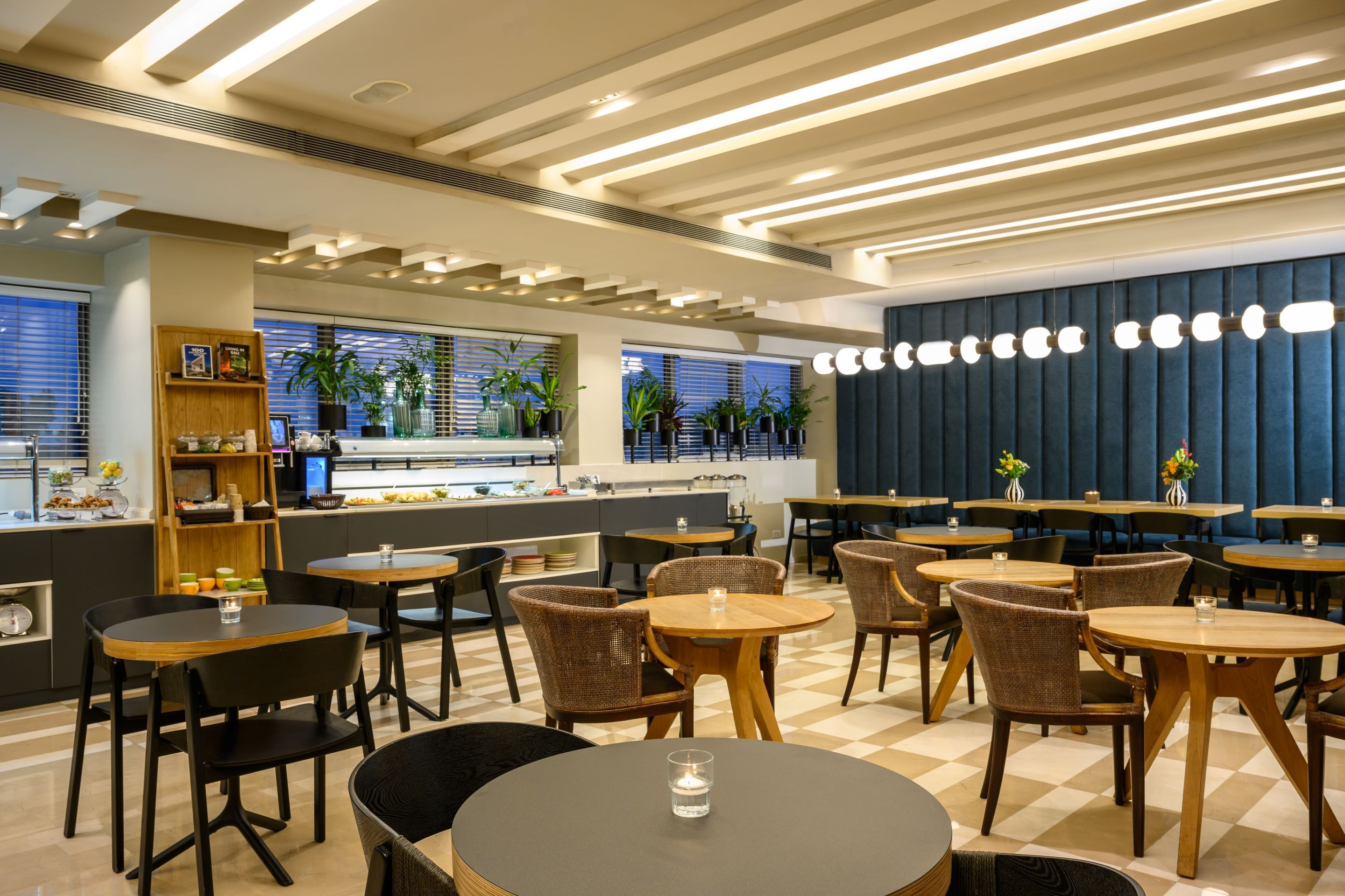 A modern restaurant interior with round tables, wicker chairs, and a checkered floor.