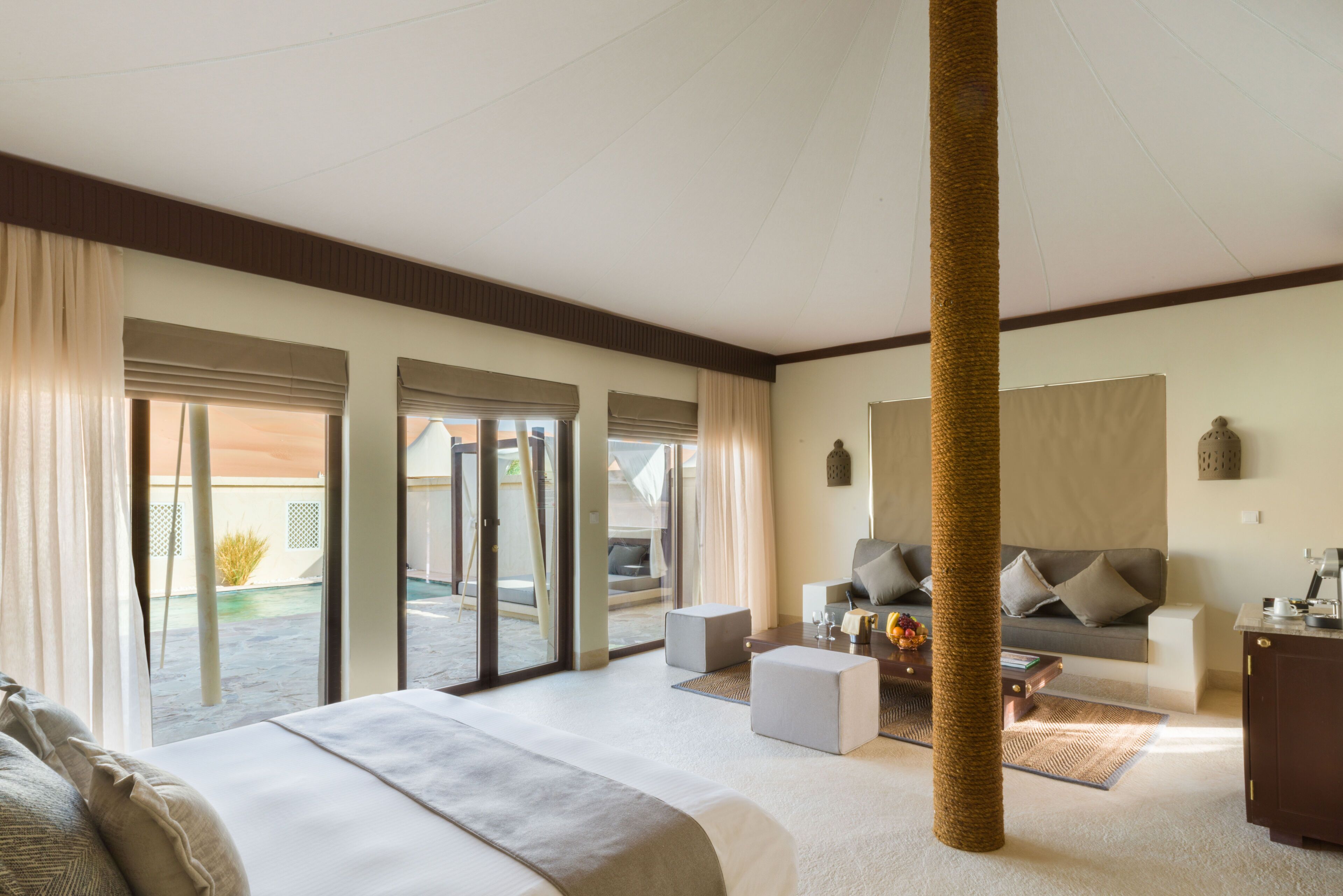 Un cuarto de hotel con una cama, un sofá, una mesita de centro y vistas al exterior.