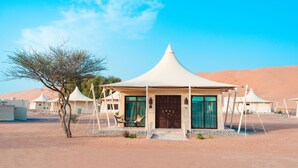 A desert resort with a central building featuring a conical roof, surrounded by smaller tents. - Desert Nights Resort (Bidiya)