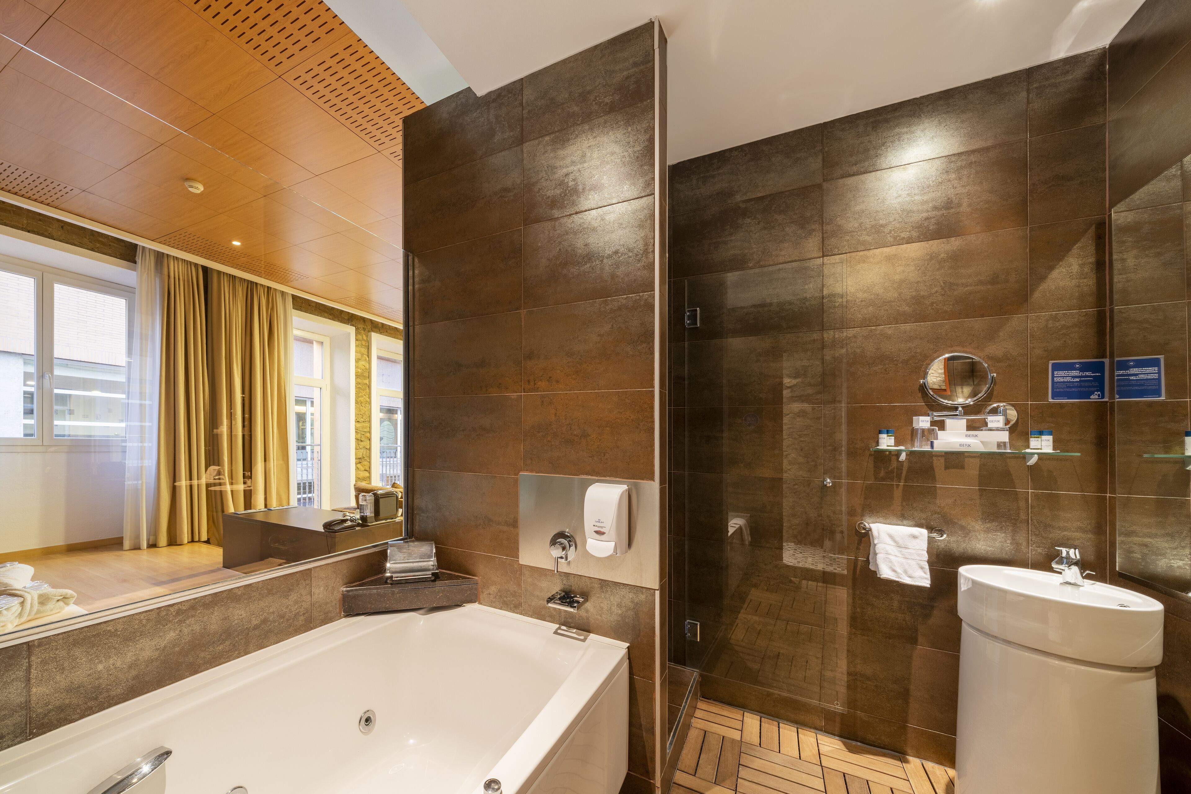 Een moderne badkamer met een groot bad, een douchecabine van glas en een wastafel.