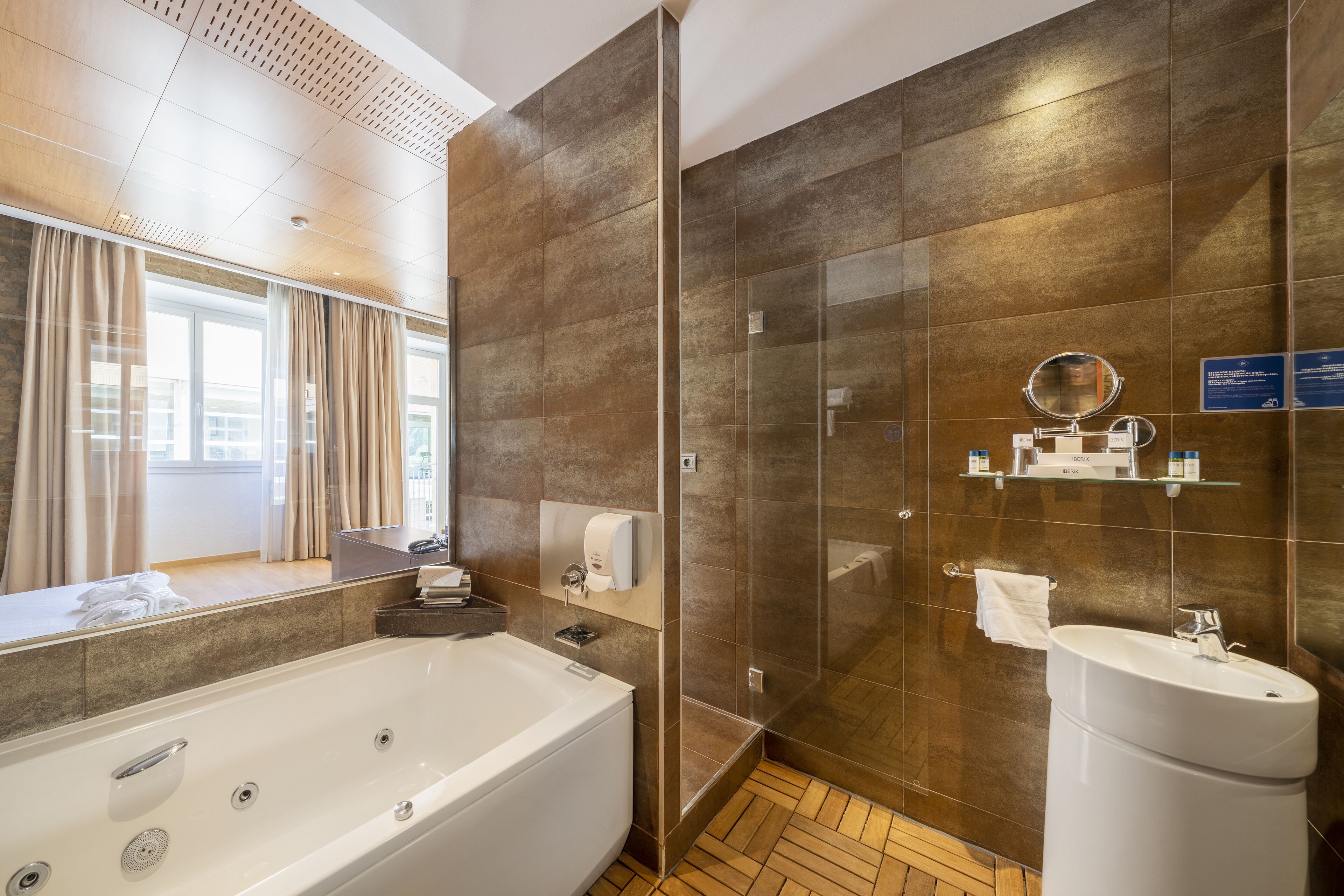 A modern bathroom with a large bathtub, a glass shower enclosure, and a sink.