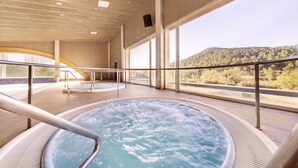 Un bain à remous avec vue sur une colline boisée.