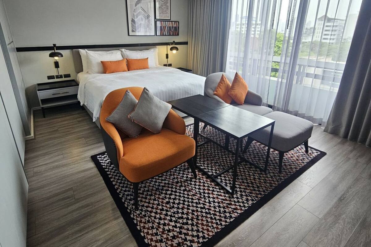 Une chambre d’hôtel moderne équipée d’un lit, d’une table à manger et d’un canapé.