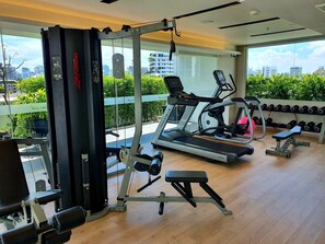 A gym with a treadmill, weight bench, and dumbbells. - Oakwood Residence Sukhumvit Thonglor Bangkok (Bangkok)