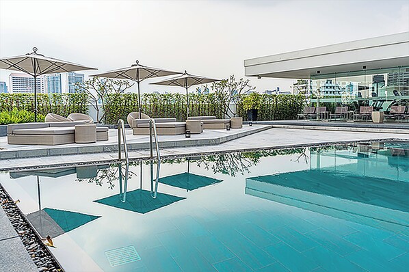 Alberca al aire libre y camastros