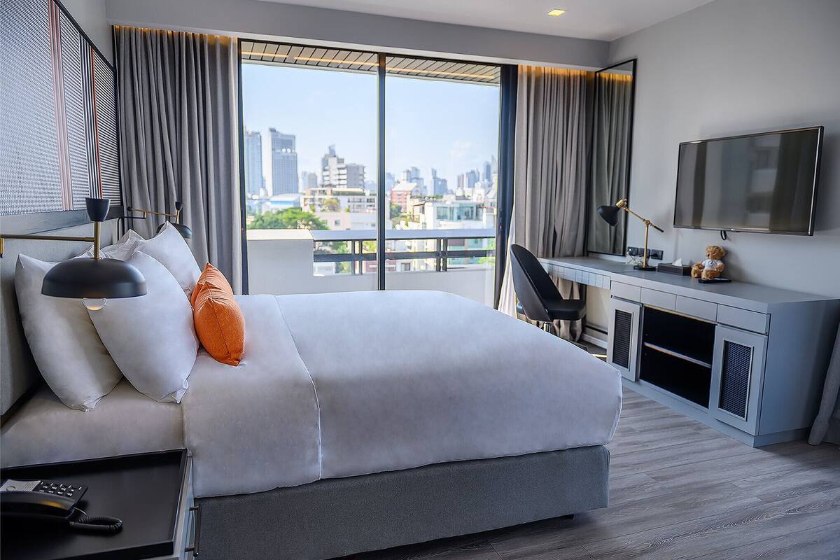 Une chambre d’hôtel moderne avec un grand lit, un bureau et une vue sur la ville.