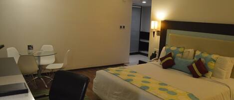 Una habitación de hotel con cama, escritorio y silla.